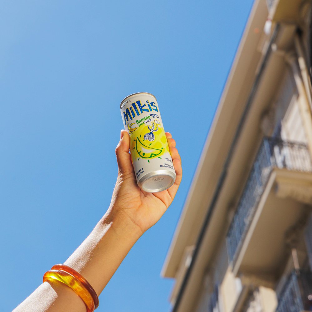 Canette de Milkis levée vers le ciel bleu