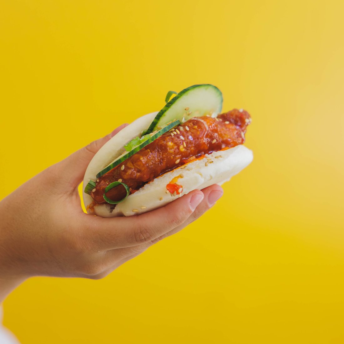 Chikin Bao Chungchun tenu à la main sur fond jaune vif
