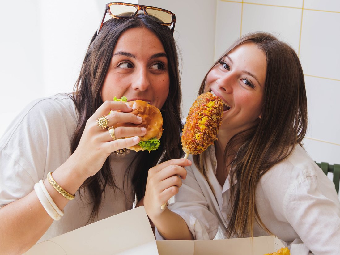 Amies partageant des Rice Dogs et des frites en salle