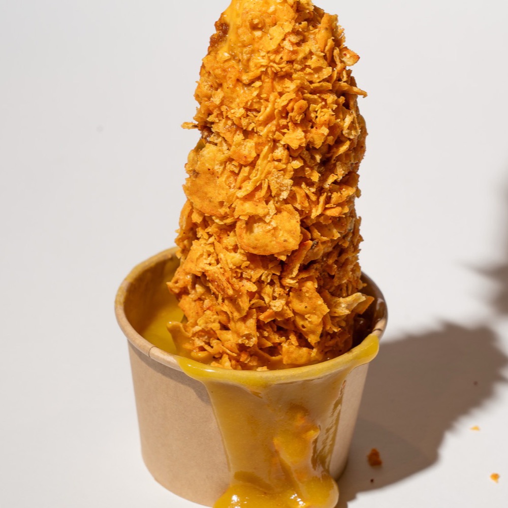 Rice Dog trempé dans le cheddar fondu